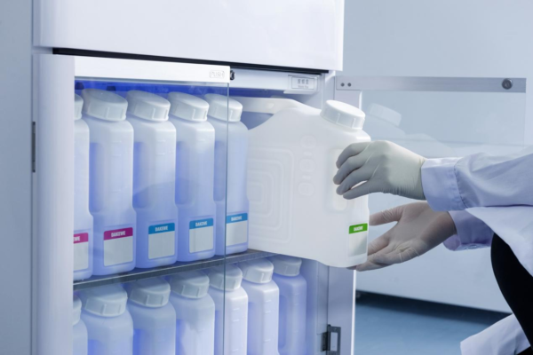 A person in a lab coat is opening a refrigerator to retrieve samples to be processed using the HP300 Automatic Tissue Processor, maximum 300 Cassettes, 150 Cassettes per Basket.