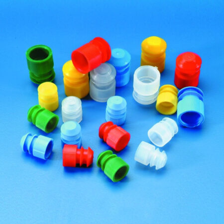 Yellow LDPE push-in stoppers, 15-17mm (1000/bag), are scattered on a blue surface among assorted colorful plastic bottle caps and closures.