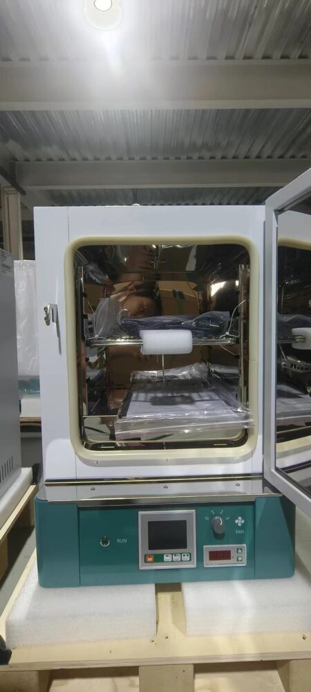 A forced air convection drying oven with an LCD controller is shown with its glass door open, revealing interior shelves and the control panel at the bottom.