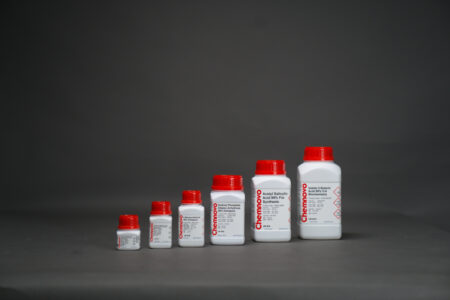 Six white plastic bottles with red caps of varying sizes are lined up in ascending order against a plain gray background.