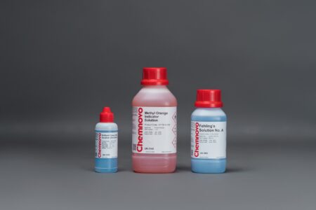 Three chemical solution bottles with red caps are arranged side by side against a gray background. The labels read "Methyl Orange Indicator Solution" and "Fehling's Solution No. A.