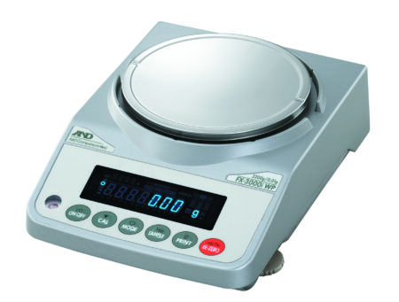 Digital laboratory balance with a round weighing platform, LED display showing zero, and several control buttons on the front panel.