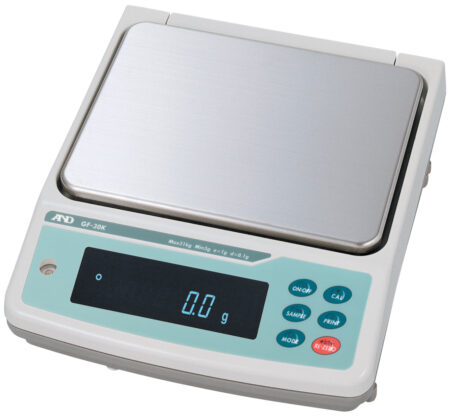 A digital laboratory scale displays "0.0 g" on its screen. The scale has a stainless steel weighing platform and several control buttons on the right side.