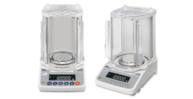Two digital analytical balances with transparent enclosures and digital displays are placed side by side on a white background.