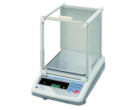 A digital laboratory balance with a transparent draft shield, a stainless steel weighing pan, and a control panel with display and buttons.