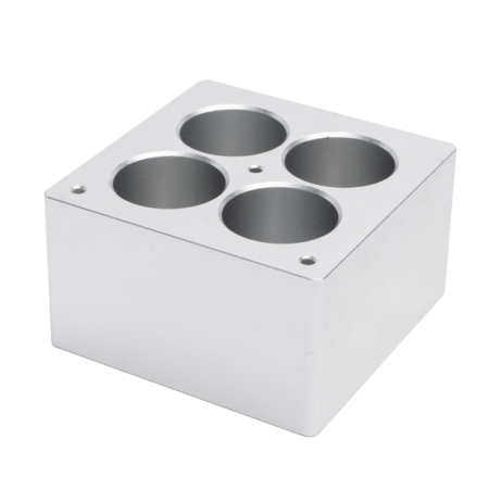A silver metal block with four cylindrical holes evenly spaced on the top surface.