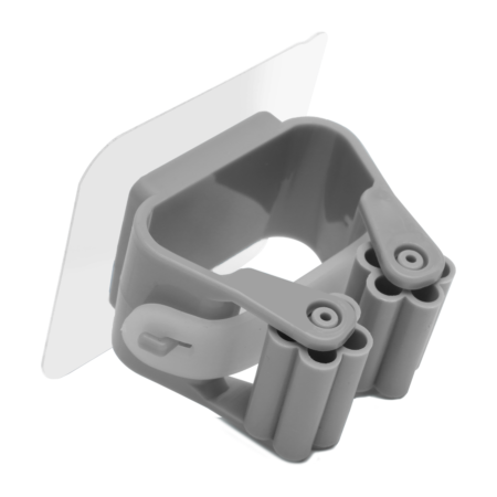 Gray wall-mounted broom holder with a clamp mechanism and an adhesive backing, designed for securing cleaning tools vertically.