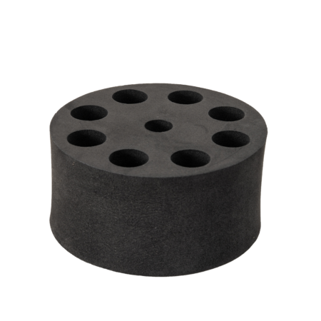Black cylindrical foam block with seven evenly spaced round holes on the top surface, likely used for holding items such as brushes or tools.