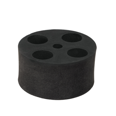 A black cylindrical foam block with four circular holes on the top surface, arranged in a cross pattern.