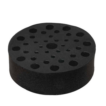 A black round foam pad with multiple circular holes of varying sizes arranged in a pattern.