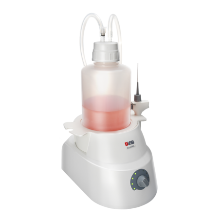 A laboratory bottle filled with pink liquid is connected to a white electronic device with control knob and indicator lights, used for processing or filtration.