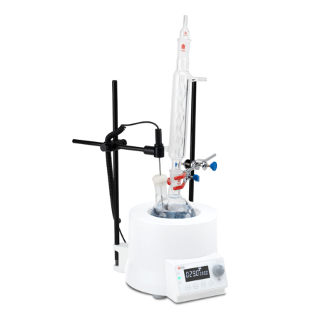 A laboratory distillation apparatus with a glass condenser, digital heating unit, and support stands, set up for chemical separation or purification.