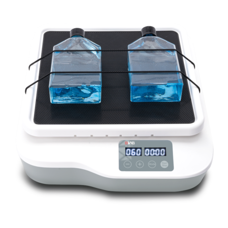 A laboratory orbital shaker with two rectangular bottles containing blue liquid secured on its platform; digital display shows "060" and control buttons.