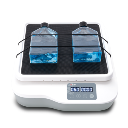 Laboratory orbital shaker with two large bottles of blue liquid secured on the platform, digital control panel displaying "060" and "00:00" on the screen.
