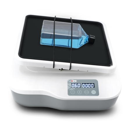 A digital laboratory shaker with a rectangular platform holding a capped flask containing blue liquid, secured by elastic bands.